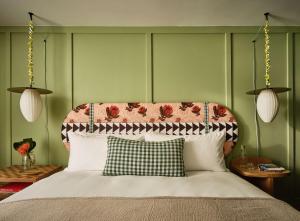 檀香山Wayfinder Waikiki的一间卧室配有一张带花床头板的床