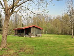 莱斯Holiday home Læsø XXV的木屋,在田野上设有长凳