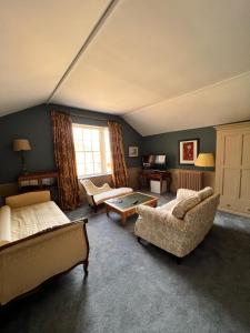 威尔斯浦Llanerchydol Hall Suites的客房设有两张床、一张沙发和一张桌子。