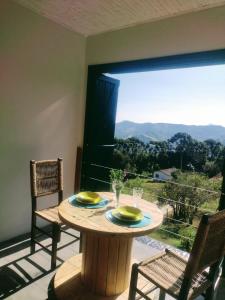 蒙特韦尔迪Montanha Home的一张桌子、两把椅子和大窗户