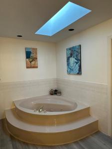 伯纳比Beautiful Home in Burnaby (Metrotown Area)的配有天窗的客房内的大浴缸