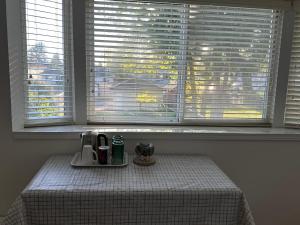 伯纳比Beautiful Home in Burnaby (Metrotown Area)的窗户前的桌子和咖啡壶