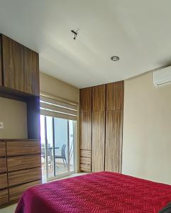 马萨特兰Dpto. Premium Torre Esmeralda的一间卧室设有一张床和一个滑动玻璃门