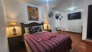 危地马拉安地瓜MAGNOLIAS的一间卧室配有一张床和一张桌子及椅子