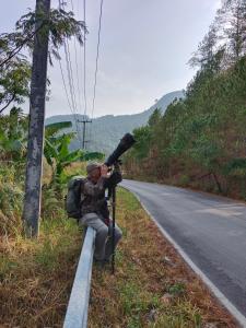 Rangbondoi - Birdwatching Included的坐在路边的男人,有照相机