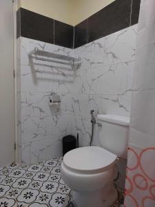 T&J Guest House的浴室配有白色卫生间和大理石墙。