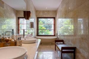 乌布Arkamara Dijiwa Ubud的大型浴室设有两个盥洗盆和浴缸。