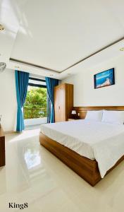 芽庄Thanh Hien villa的一间卧室配有一张带蓝色窗帘的大床