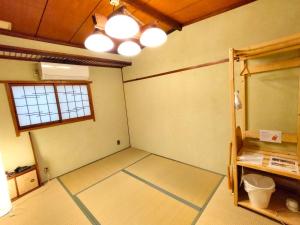 大阪Hostel Caranashi的一个空房间,有窗口和镜子