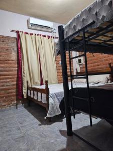 卡塔马卡El gumer的一间卧室设有两张双层床和一扇窗户。