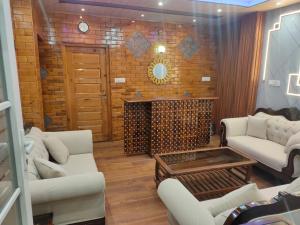 西姆拉Shimla Abode的客厅配有白色沙发和壁炉