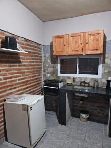 卡塔马卡El gumer的厨房配有木制橱柜和白色冰箱。