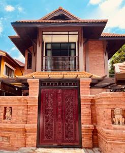 清迈Phor Liang Meun Terracotta Arts的前面有红门的房子