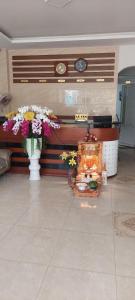 大叻Tường Lan Hotel的大堂设有两瓶鲜花和一个壁炉