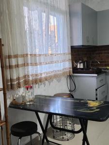 巴统53 jincharadze street的厨房配有桌子、两把椅子和窗户