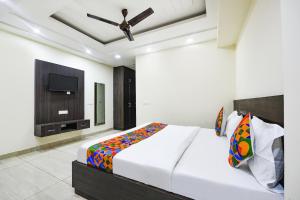新德里FabHotel Dwarka Residency的一间卧室配有一张床和一台平面电视