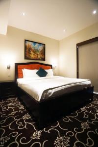 安曼内洛夫套房酒店的卧室配有一张大床,墙上挂有绘画作品