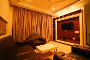 蒂鲁帕蒂Golden Villa - duplex with private theater - A Golden Group Of Premium Home Stays - tirupati的带沙发和平面电视的客厅