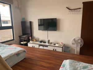 东港豆豆龙亲子民宿 的卧室配有壁挂式平面电视。