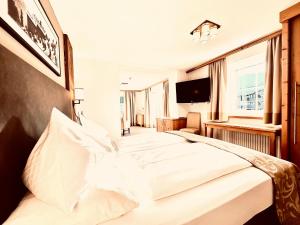 阿尔滕马克特蓬高乌尔比斯古特酒店的卧室配有一张白色大床和电视。