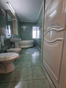克拉约瓦Hotel Green House的浴室设有2个卫生间、水槽和浴缸。