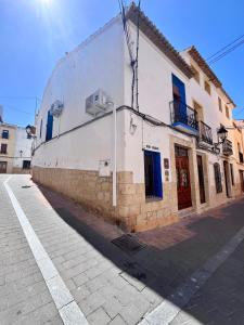 拉努西亚Casa Rural Les Avies cerca del mar的白色的建筑,街道上设有蓝色的门