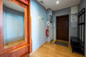 什切青Apartament MonteCassino的走廊上设有门,墙上设有镜子