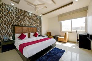 新德里The EL DE Belwood Hotel By Delhi Airport的一间卧室配有一张带红色枕头的大床