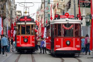 伊斯坦布尔Pera Rose Hotel - Taksim Pera的两辆红色推车在城市街道上,人们在街上
