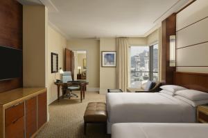 麦加Conrad Makkah的酒店客房配有一张床、一张书桌和一台电视。