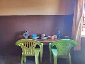 利文斯顿Simoonga Thandizani School的一张桌子、两把椅子和一张桌子,桌子上放着盘子和杯子