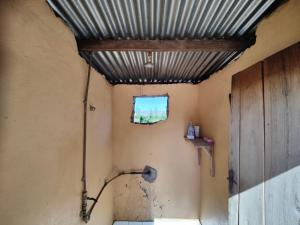 利文斯顿Simoonga Thandizani School的一间带金属天花板和窗户的浴室