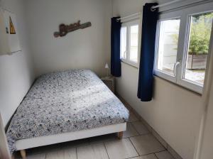 滨海卡约La cabine en Baie de Somme的一间小卧室,配有床和2个窗户