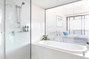黄金海岸Sealuxe - Central Surfers Paradise -- Ocean View Deluxe Residences的白色的浴室设有浴缸和窗户。