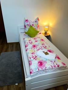 菲沙门德多夫Frühstückspension Elena Nicoleta Caltun的一张带花卉图案的床铺和枕头