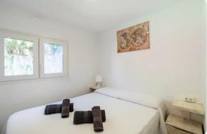 博罗尼亚Apartamento en Bolonia的卧室配有白色的床和黑色拖鞋