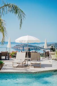 勒·雷约尔·卡纳德尔·苏尔顿斯别墅酒店的一个带椅子和桌子的游泳池以及一把遮阳伞