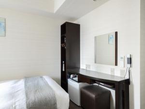 广岛广岛站前船只酒店 的一间卧室配有一张桌子、一张床和一面镜子