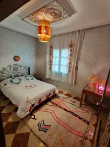 马拉喀什DAR SARSAR airport的一间卧室配有一张床、地毯和吊灯