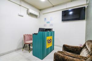 加尔各答FabHotel Grand Hazra Inn的一间设有两把椅子和一台墙上的电视的房间