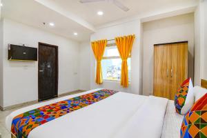 加尔各答FabHotel Grand Hazra Inn的一间卧室设有一张大床和一个窗户。