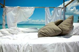 邦劳Ananyana Leisure Beach Resort的一张白色的床,上面有枕头