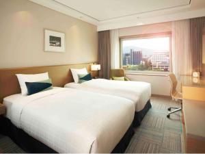 首尔首尔江南大使诺富特酒店的酒店客房设有两张床和窗户。