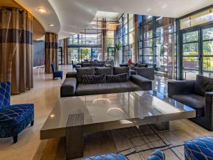 波城Hotel Parc Beaumont & Spa Pau - MGallery的带沙发和玻璃桌的客厅
