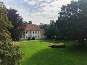 克洛彭堡克洛城堡公园酒店的一座白色的大房子,有一个大院子,有草地