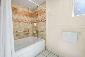 南太浩湖Econo Lodge Inn & Suites Heavenly Village Area的带窗户的浴室内的白色浴缸