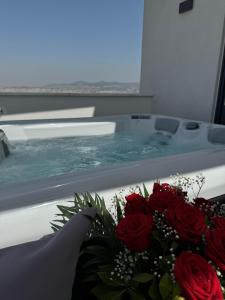 塞萨洛尼基SIGMA Luxury Apartments & Suites的浴室设有花束玫瑰花的浴缸
