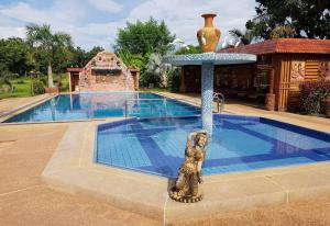 Ban Nong PhaiChangthai Comfort Guest House的游泳池喷泉旁的雕像