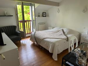 于斯塔里茨LES CHAMBRES D'ARRAUNTZ的卧室配有床、椅子和窗户。