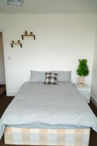 布赖尔利希尔2 Bedroom Apartment Brierley Hill的卧室内的一张床位,卧室设有白色的墙壁